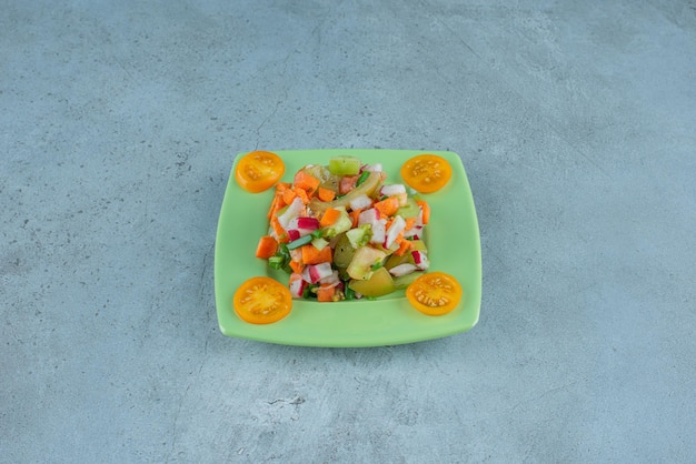 Салат из рубленых фруктов в керамической тарелке на бетоне.