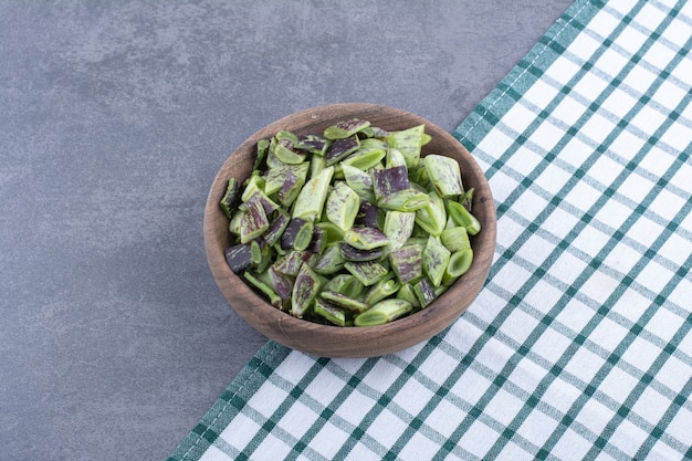 Chopped green beans inside a cup on blue surface