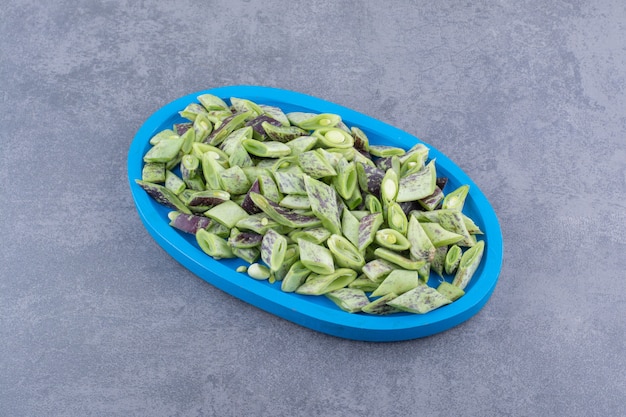 푸른 표면에 있는 냄비에 다진 녹색 콩