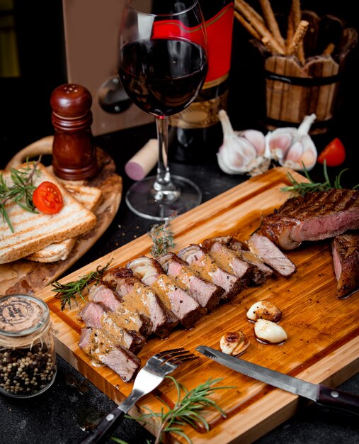 Chopped pieces of steak on a wooden board and garlic