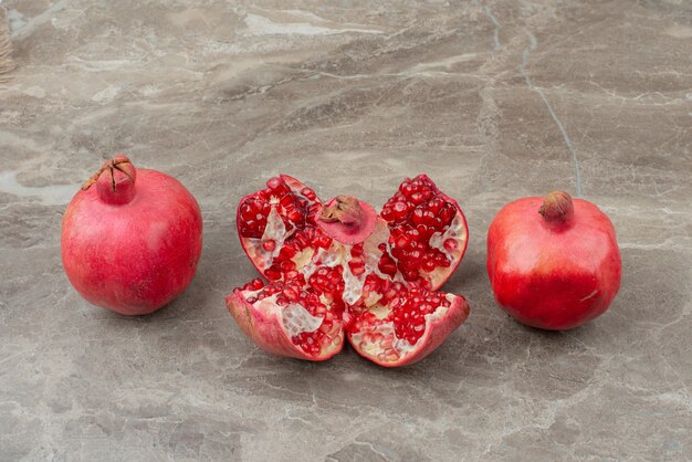 Chopped pomegranates and seeds on marble table