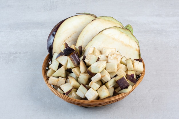 Chopped raw eggplants in wooden bowl. High quality photo