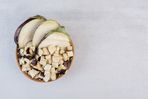 Chopped raw eggplants in wooden bowl. High quality photo