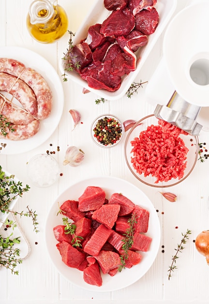 Chopped raw meat. The process of preparing forcemeat by means of a meat grinder. Homemade sausage. Ground beef. Top view