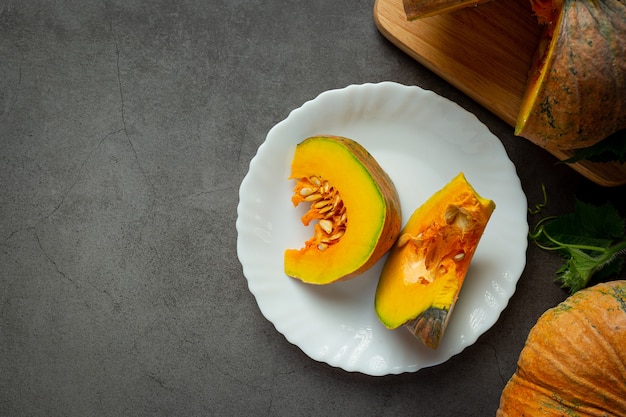 Chopped raw pumpkin placed on a white ceramic plate