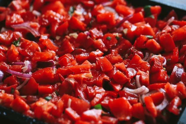 Chopped red tomatoes with herbs in a black pan