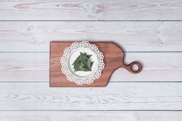 Chopping board with ornament plate and green leaves