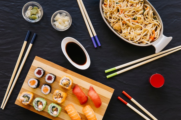 Foto gratuita bacchette vicino a sushi e noodles