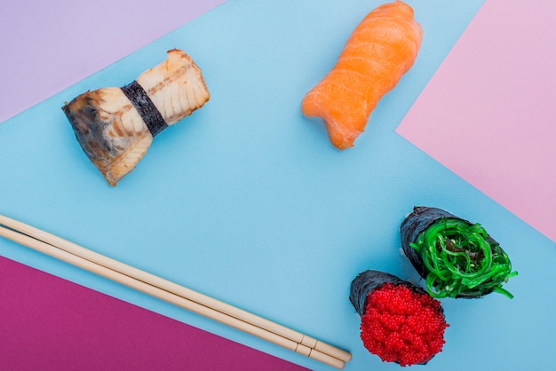 Бесплатное фото Палочки для еды и суши роллы на столе
