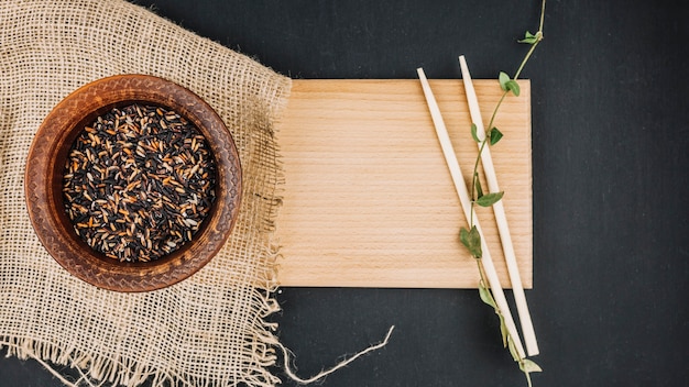 Foto gratuita bacchette e riso nero su tavola di legno