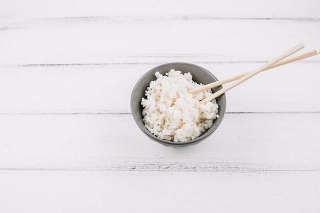 Chopsticks in bowl with rice