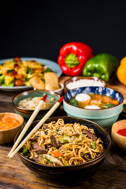 Chopsticks over the bowls of thai cuisine