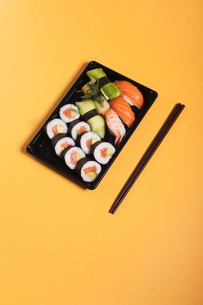 Foto gratuita bacchette vicino set di sushi