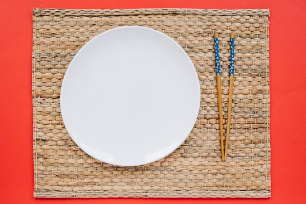 Палочки для еды и тарелки на салфетке