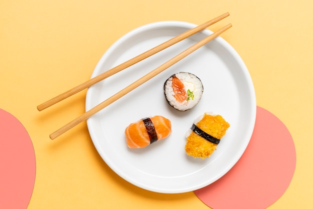 Chopsticks on plate with sushi