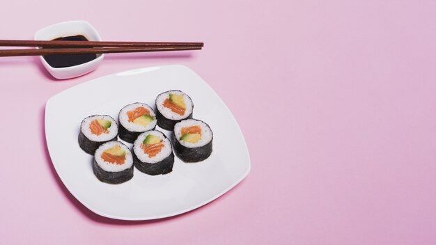 Foto gratuita le bacchette sulla salsa di soia vicino sushi