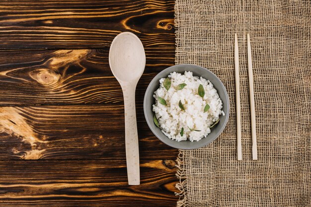 Chopsticks and spoon near boiled rice