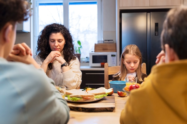 Foto gratuita famiglia cristiana che prega insieme