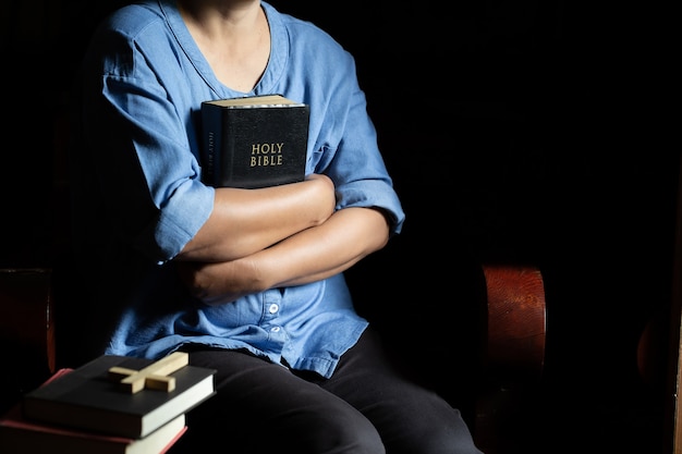 Foto gratuita una donna cristiana era seduta su una sedia di legno