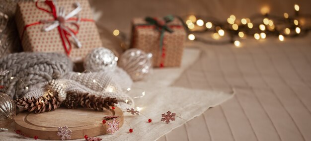 소나무 콘, 화환, 선물 상자, 가정 장식 세부 사항 및 흐릿한 조명의 크리스마스 배경 구성 공간을 복사합니다.