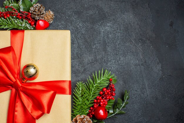 Christmas background with beautiful gifts with bow-shaped ribbon and fir branches decoration accessories on a dark table half shot photo