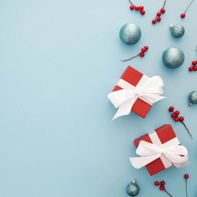 Рождественский фон с синими шарами, красными подарками и омелой