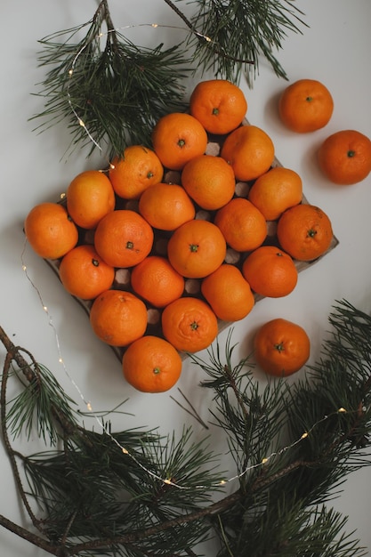 Новогодний фон с еловыми ветками и мандаринами с рождеством и новым годом greeti ... Premium Фотографии