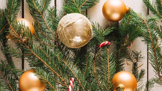 Рождественский фон с золотыми шарами и еловыми ветками