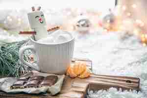 Free photo christmas background with marshmallow snowman in a cup