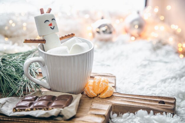 컵에 마시멜로 눈사람이 있는 크리스마스 배경
