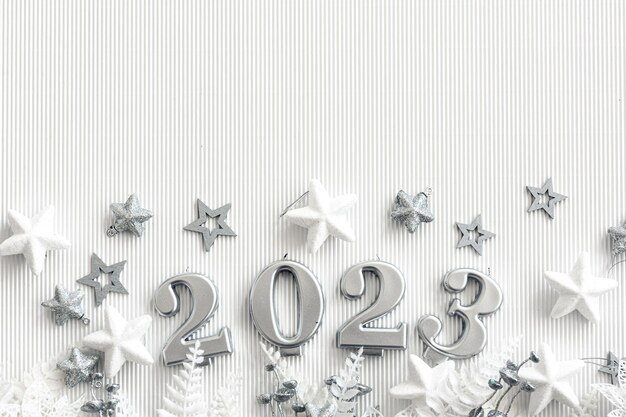 Новогодний фон с цифрами 2023 и декором на белом фоне