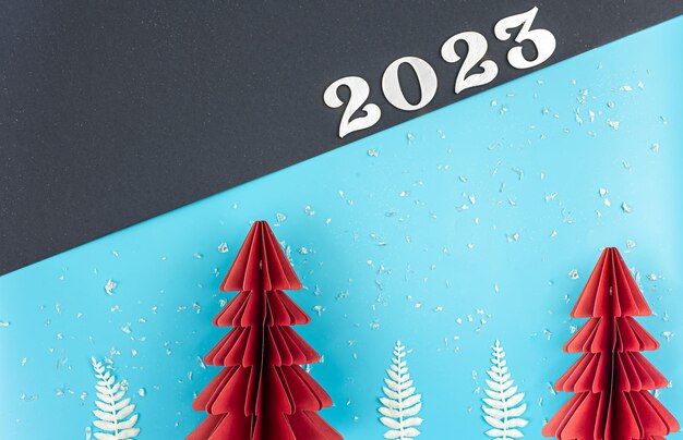 クリスマスの背景に折り紙の紙の木と番号 2023 フラット レイアウト