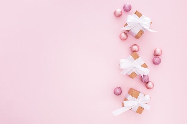 Christmas balls and gifts on a pink background