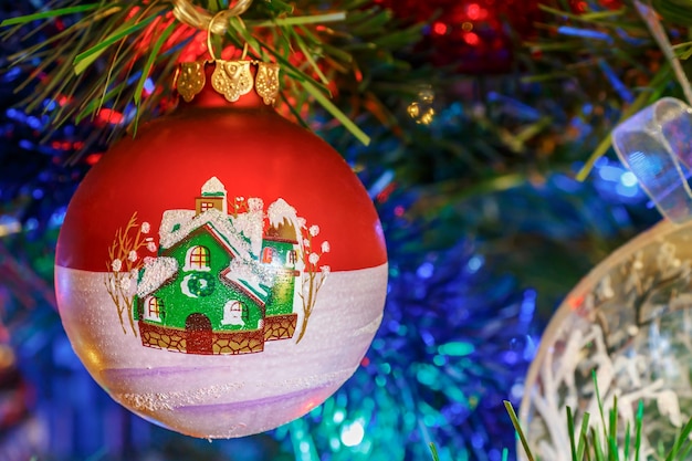 装飾的​な​モミ​の​クローズアップ​の​枝​に​色​の​花輪​を​持つ​クリスマス​ボール