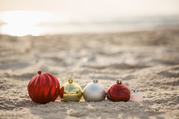 Christmas baubles arranged on the sand