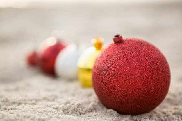 Christmas baubles arranged on the sand