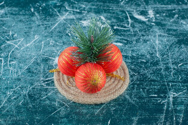 christmas baubles arranged on a trivet on marble.