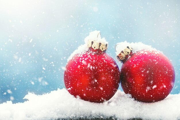 Christmas baubles or decorations on a snow on a bright winter background, christmas or holidays concept, copy space