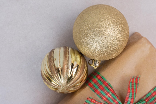 Christmas box with golden balls on gray table