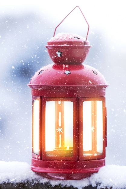 Christmas candle lantern on a snowy background outside, christmas concept