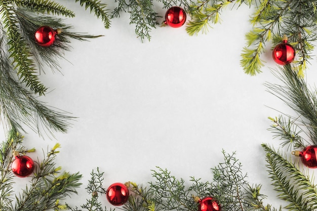 Christmas composition of branches with red baubles 