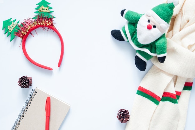 Christmas composition. Christmas fashion for girl, cosmetics, bag, pine cones, notebook and red pen with copy space. Flat lay, top view