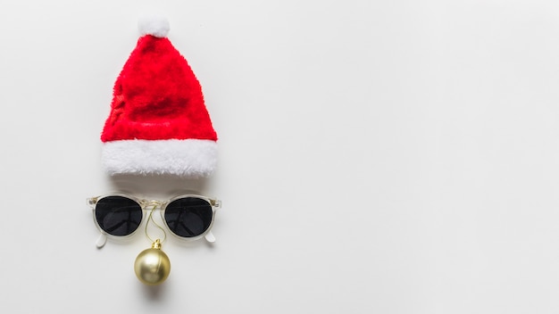 帽子とサングラスからの顔のクリスマスの構成