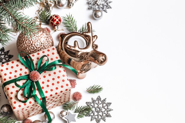 クリスマスの組成物。ギフト、モミの木の枝、白い壁に赤い装飾。冬、新年のコンセプトです。フラットレイアウト、等尺性、テキスト用のスペース