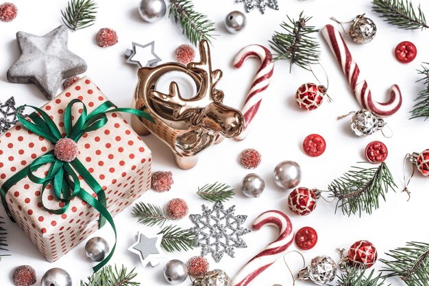 クリスマス作曲。贈り物、モミの木の枝、白い壁に赤い装飾。冬、新年のコンセプト。フラットレイ、アイソメビュー