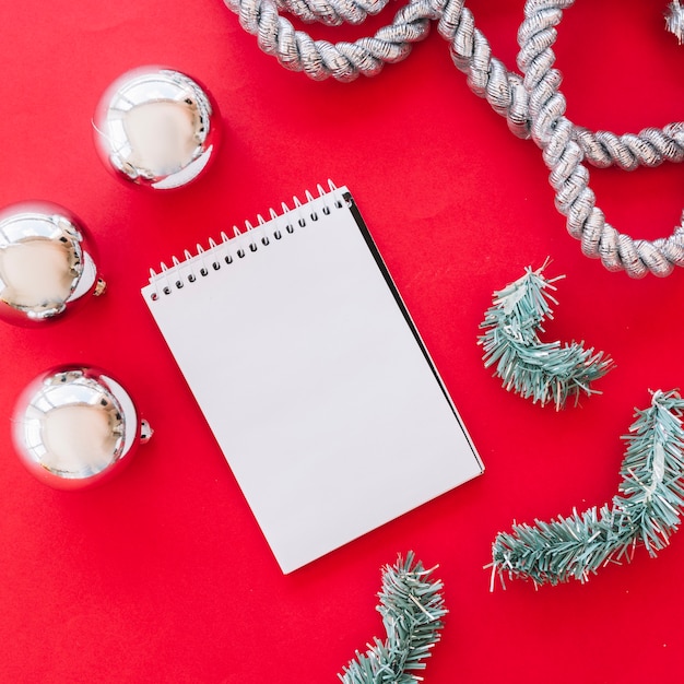 Christmas composition of notepad with shiny baubles