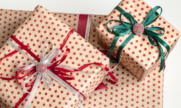 Christmas composition of various gift boxes wrapped in craft paper and decorated with satin ribbons. Top view, flat lay.