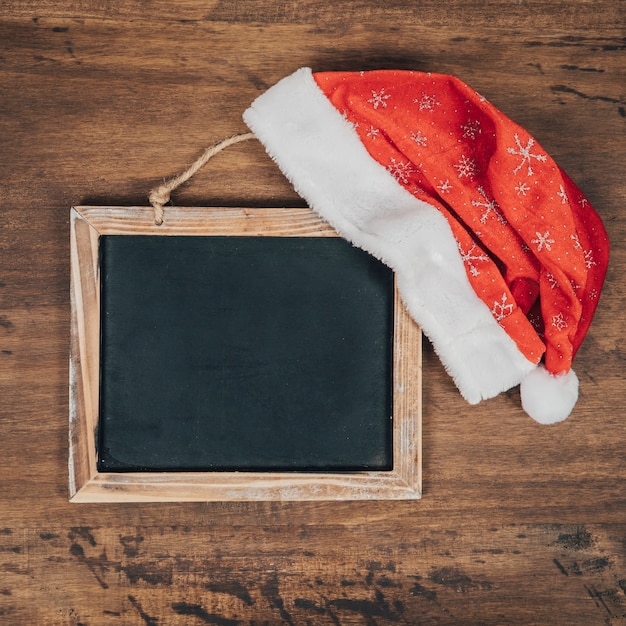 Foto gratuita composizione di natale con cappello di natale su ardesia