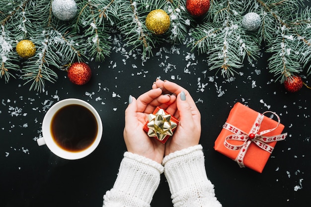 Бесплатное фото Рождественская композиция с кофе и руки с подарком