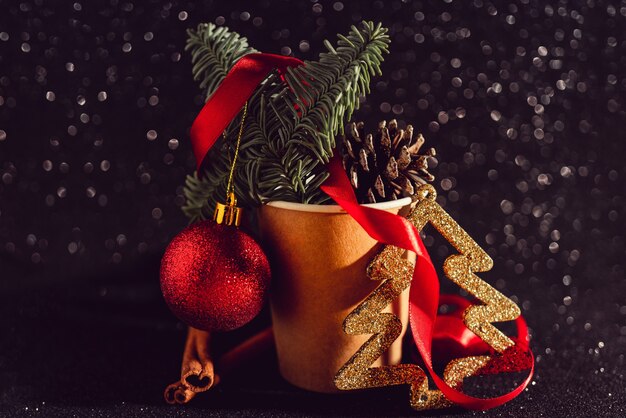 Christmas composition with fir cones in a paper coffee cup, holiday decoration elements